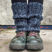 Load image into Gallery viewer, Person wearing blue knitted leg warmers over black leggings with green boots on a concrete surface.