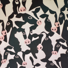 Load image into Gallery viewer, A close-up of a fabric  pattern featuring a dense, stylized cow print in black, off-white, and light pink.
